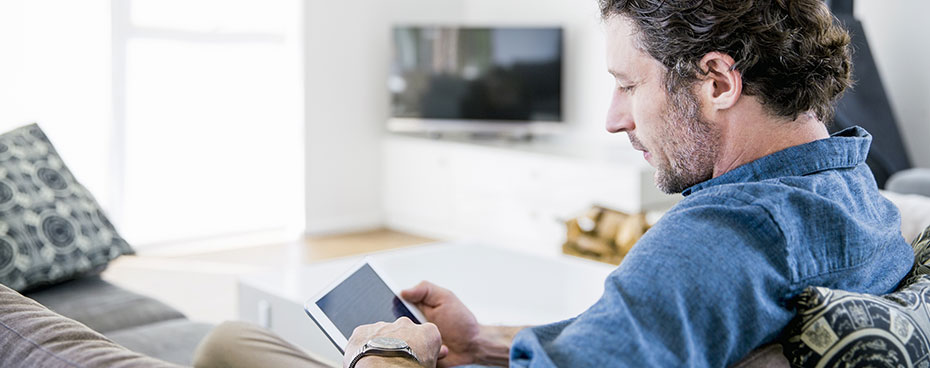 Man leest over de belangrijkste beleggingsrisico's op zijn tablet. Man leest over de belangrijkste beleggingsrisico's op zijn tablet.